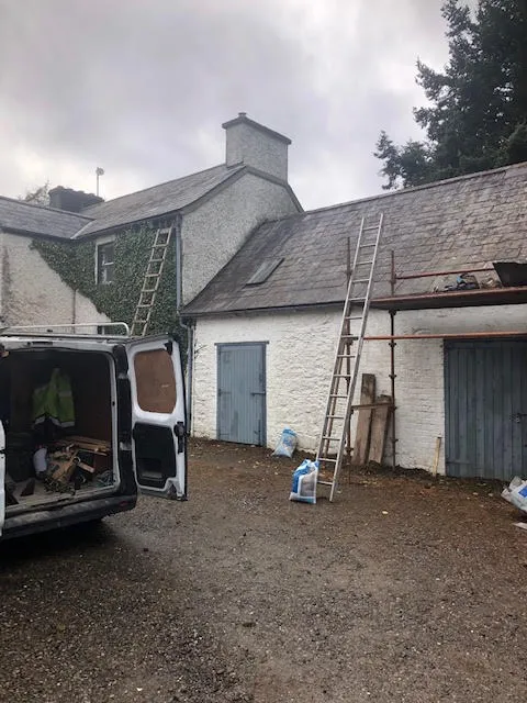 Moss growth on the roof being cleared and broken slates replaced — photo 8